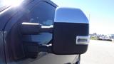 Close-up of the side mirror of a 2017 Ford F-350 SD featuring a chrome cover and integrated turn signal light