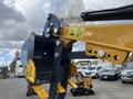 A close-up view of the attachment on a 2024 AGT Mini Excavator showing the bucket and connecting arm with safety labels and hardware