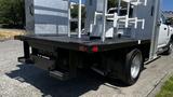 A 2019 RAM 3500 with a flatbed and mounted equipment storage features visible on the back of the vehicle