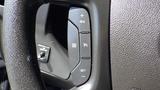 Steering wheel controls of a 2015 GMC Savana featuring buttons for cruise control and settings