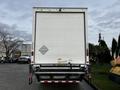 White 2022 Ford F-750 truck with a large cargo box and rear entry door facing the viewer