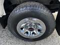 A close-up of a chrome wheel with a GMC logo and a rugged tire on a 2017 GMC Sierra 1500