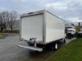 A 2019 Ford Econoline truck with a white cargo box and rear loading access in a parking area