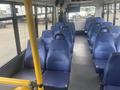 Interior view of a 2017 Chevrolet Express featuring several rows of blue upholstered seating designed for passenger transport