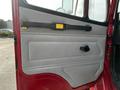 Door interior of a 1994 Freightliner FL80 featuring a gray panel with a black handle and a yellow latch