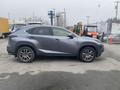 A 2021 Lexus NX 300 in a sleek gray color with five-spoke alloy wheels parked with its side facing the viewer