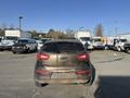 A 2012 Kia Sportage parked in a lot with a dirty exterior and rear view visible