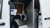 Interior view of a 2012 Ford Transit van showing a metal partition a storage box and wooden panels