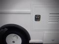 A white 2003 Freightliner MT45 Chassis featuring a closed side door with a circular chrome handle and a ventilation grille near the wheel