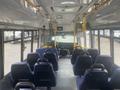 Interior view of a 2017 Chevrolet Express bus showing rows of blue seats and the driver's area at the front with dashboard and steering wheel visible