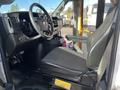 Interior of a 2018 Chevrolet Express showing the driver's seat steering wheel and dashboard with controls and cup holder