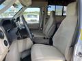 Interior view of a 2012 Ford Econoline showcasing two front seats and the dashboard with various controls and displays