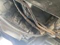 A 1966 Ford Mustang with visible undercarriage components including a transmission and various pipes showing signs of wear and rust