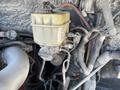 Close-up of a yellow fluid reservoir mounted on a 2010 Freightliner MT45 garbage truck surrounded by various hoses and wiring