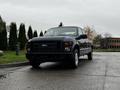 A black 2008 Ford F-250 SD pickup truck parked on a paved surface with a view of its front and side