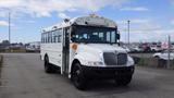 A white 2015 International PC105 school bus with a large windshield and multiple roof lights parked on a lot