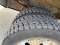 Close-up of two large, rugged tires mounted on a 2010 Ford F-550 vehicle showing deep treads designed for traction