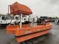 A 2008 Fassmer 20 Foot Fast Rescue boat with an orange hull and a high cabin for visibility and control