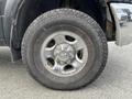 Close-up of a silver alloy wheel with a rugged tire on a 2010 Dodge Ram showcasing the wheel design and tread pattern