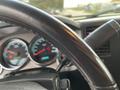 A 2013 Chevrolet Silverado Hybrid dashboard showing speedometer and fuel gauges with a steering wheel partially visible in the foreground