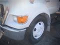 A white 2006 Ford F-650 featuring a prominent front wheel and shiny chrome details on the fender and headlight