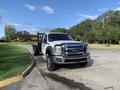 A 2013 Ford F-450 SD with a flatbed design parked on a road