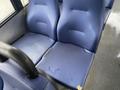 A row of two blue bus seats with a textured surface showing some wear and minor stains