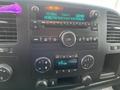 The dashboard of a 2013 Chevrolet Silverado Hybrid featuring a radio display control knobs and air conditioning settings