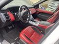 Interior of a 2020 Land Rover Range Rover Sport featuring red and black leather seats a modern dashboard and a central console with controls and a gear shift