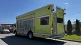 A bright yellow 1995 Freightliner FLL086 vehicle with horizontal red stripes and side windows designed for utility or service use