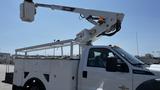 A 2011 Ford F-450 SD utility truck with a raised aerial work platform and a storage compartment in the truck bed