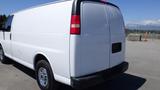 A white 2012 GMC Savana van with a smooth rear design and chrome wheels positioned at an angle