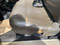 A worn and damaged leather seat of a 2010 Ford F-550 with visible tears and frayed edges