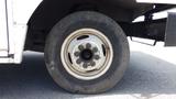 A white wheel of a 2011 Ford Econoline showing a worn tire and a five-bolt pattern on the rim