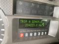 Dashboard display of a 2010 Ford F-550 showing trip distance and total kilometers with indicators for fuel type and transmission settings