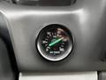 A close-up of an air pressure gauge showing the PSI levels with a green indicator needle pointing towards the upper range