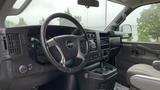 Interior view of a 2017 Chevrolet Express Quigley 4x4 showing the steering wheel dashboard and center console with storage and cup holders