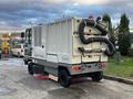 A 2007 Tennant Sentinel cleaning machine with a gray and white body featuring large vacuum hoses and a rear-mounted vacuum system for street cleaning