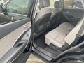 2017 Hyundai Santa Fe showing the rear interior seating area with two seats in a light gray fabric and door panel in black and gray