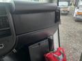 Interior view of a 2017 Chevrolet Express dashboard showing the center console and storage compartment with a red bag on the floor