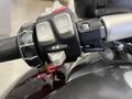 Close-up of the handlebar controls of a 2013 BMW K1600GTL featuring buttons for menu navigation and a red ignition switch