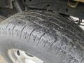 Close-up of a worn tire from a 2013 Ford F-150 showing visible tread wear and debris embedded in the rubber