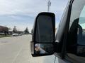 Close-up of the side mirror of a 2019 Mercedes-Benz Sprinter with a reflection of the photographer's hand visible in the mirror