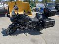 A black 2021 Harley-Davidson RA1250 S motorcycle featuring dual side panniers and a windscreen