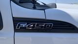 Close-up of a 2011 Ford F-450 Super Duty emblem on a white truck showcasing the model designation F-450 and the Super Duty branding