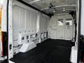 Interior of a 2020 Ford Transit van featuring a spacious cargo area with a rubber floor mat and white walls without any shelving or compartments