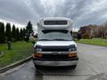 A 2017 Chevrolet Express with a white front and black grille facing directly towards the viewer