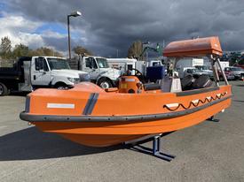 A 2007 Fassmer 20 Foot Fast Rescue Boat with an orange hull and a cabin top featuring a prominent windshield and a central outboard motor on the stern