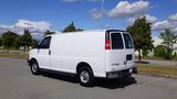 A white 2015 GMC Savana van parked with a plain design and black accents on the rear doors and windows