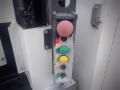 Control panel with a red stop button a yellow button and a green button along with indicator lights for operational status